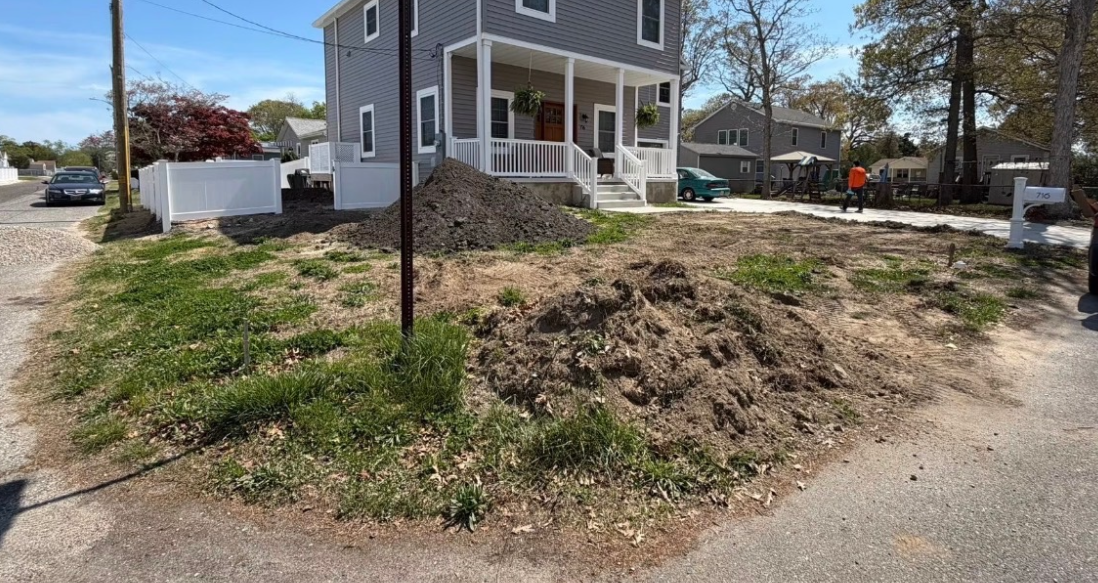 Patchy dirt front yard before new sod installation at a Cape May County home